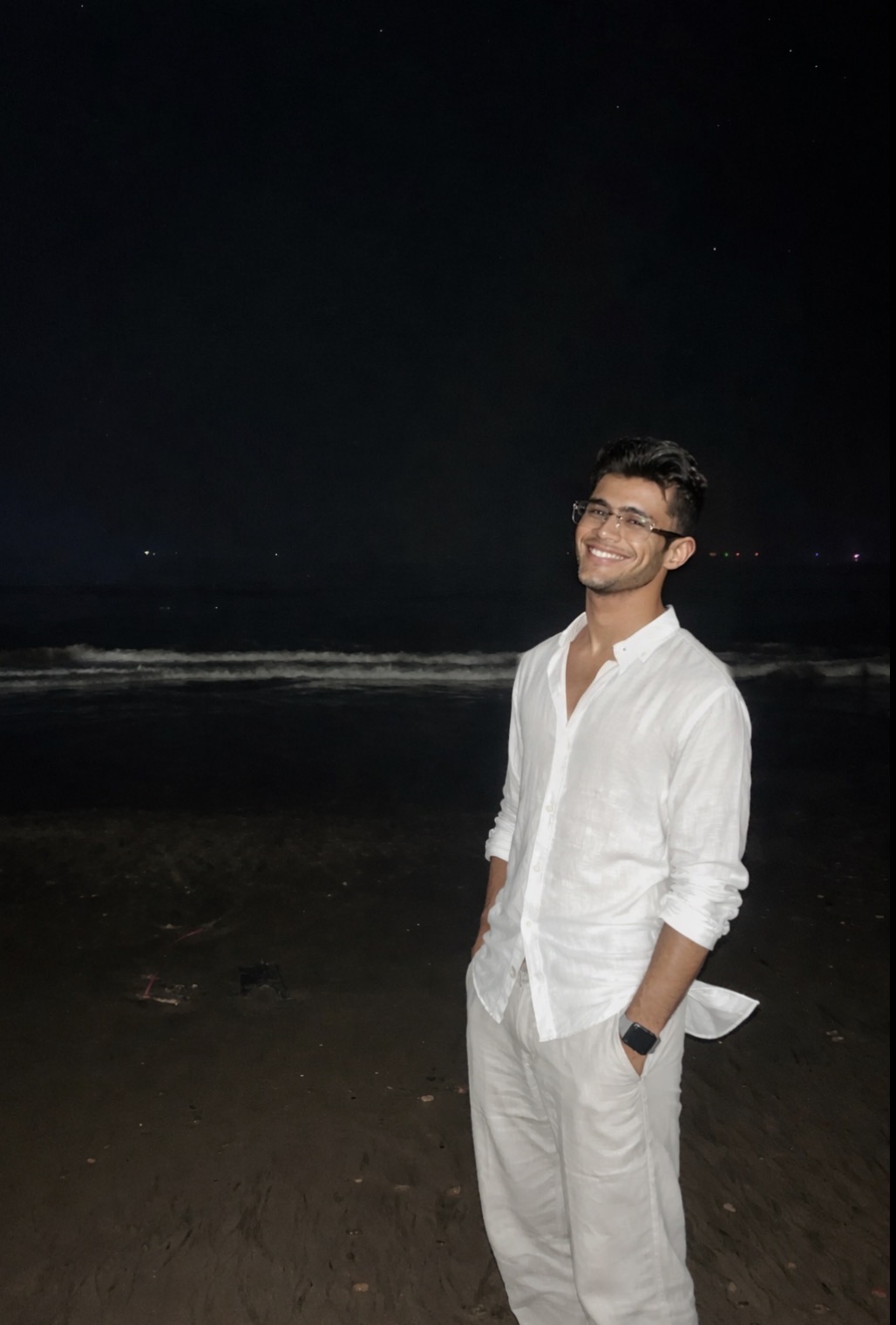 Atharva Sharma white linen shirt and glasses on night beach