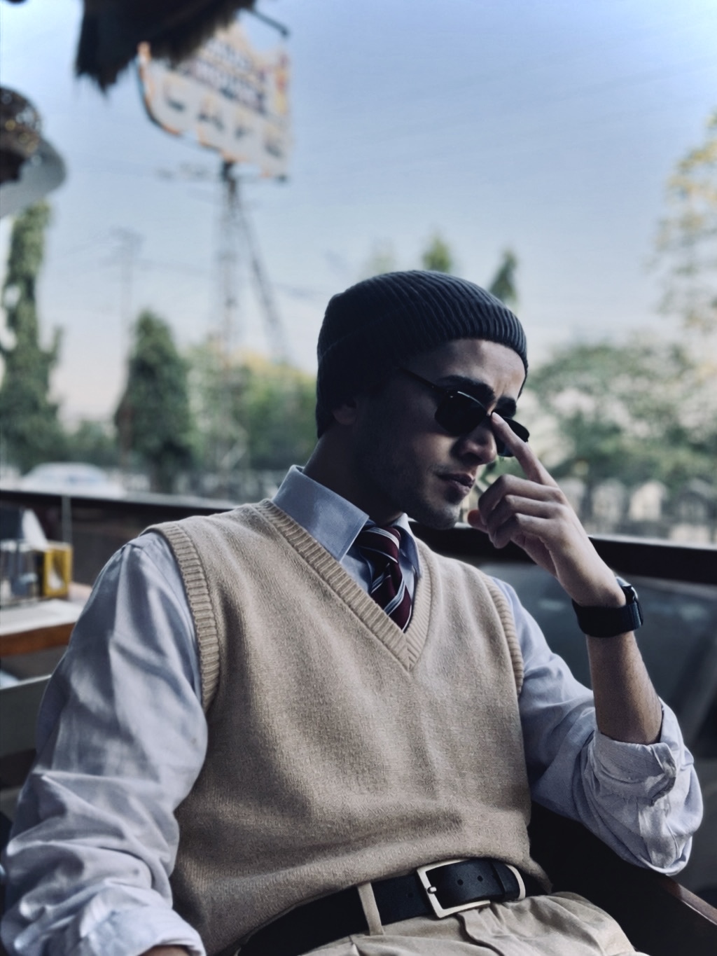 Atharva Sharma knit sweater vest tie and beanie at cafe terrace