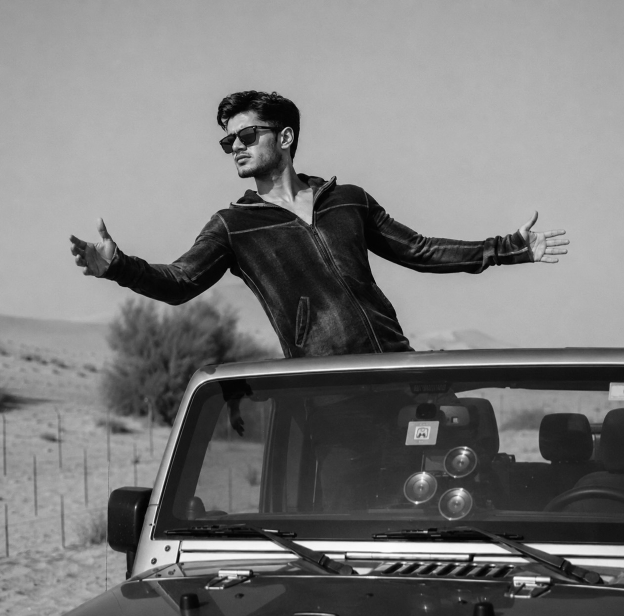 Atharva Sharma in jeep sunroof open desert landscape